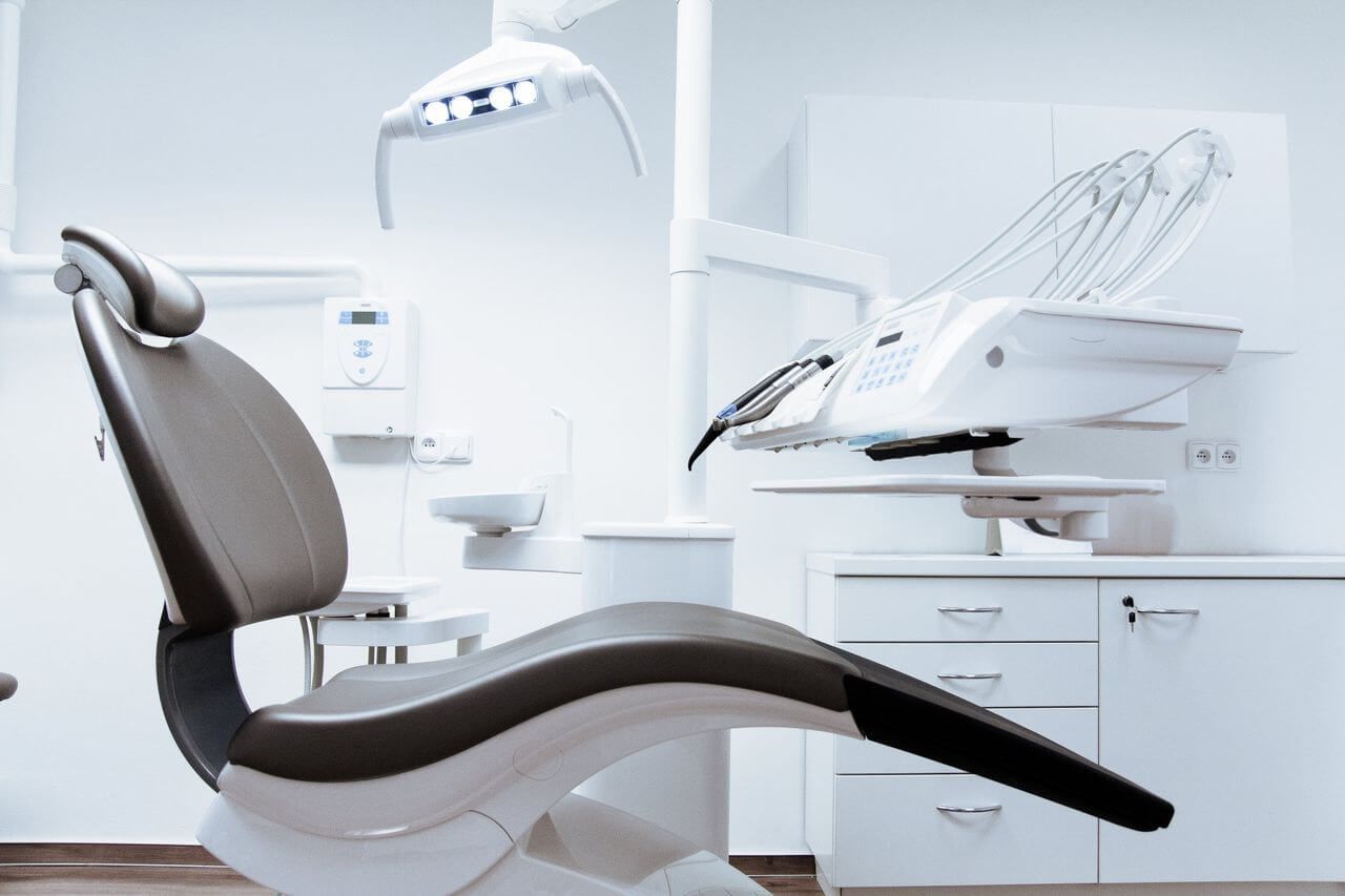 A dental chair is sitting in an empty dental office.