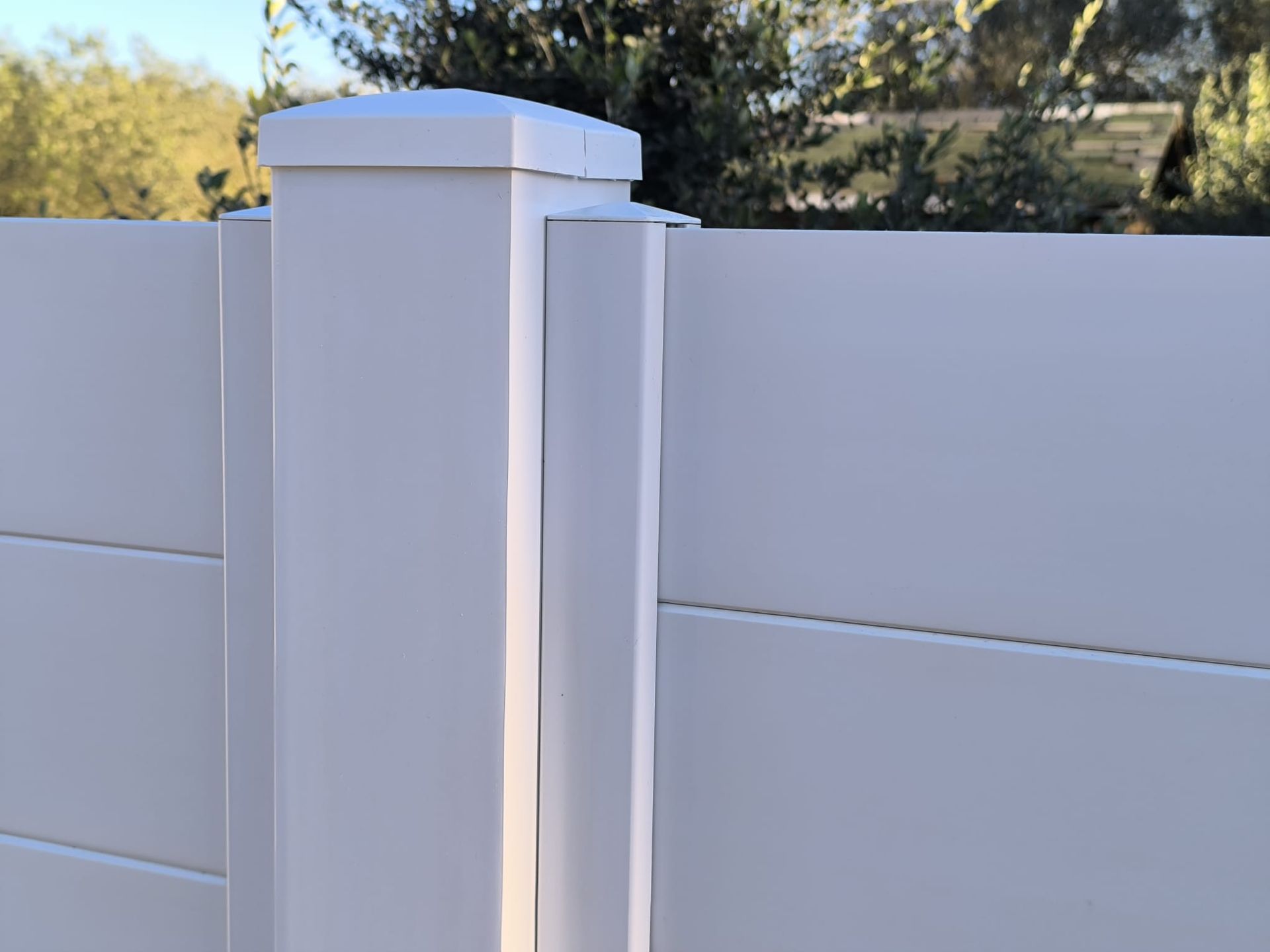 Recinzione in vinile bianco con pali quadrati e assi orizzontali.