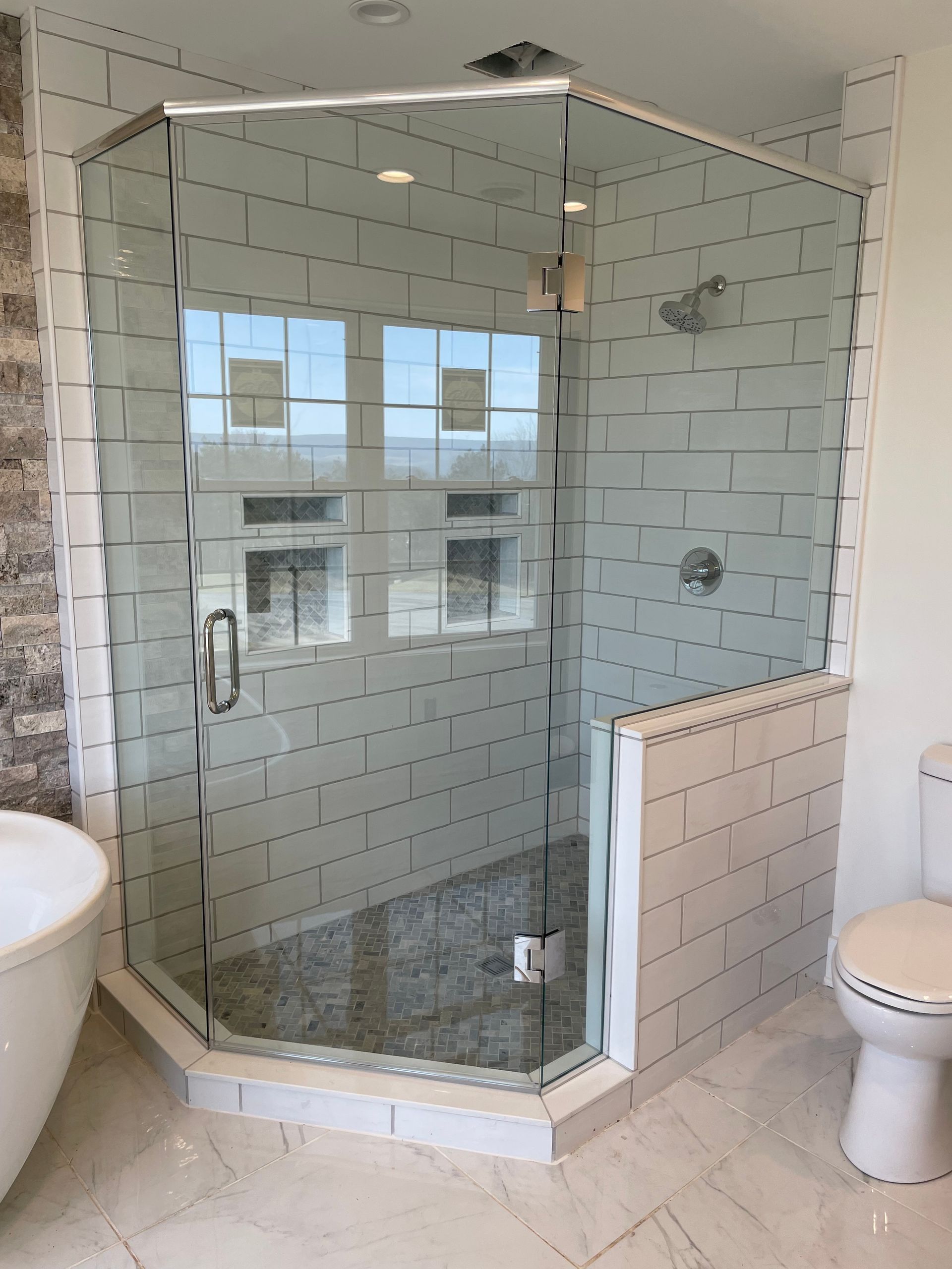 A bathroom with a bathtub, toilet, and shower stall.
