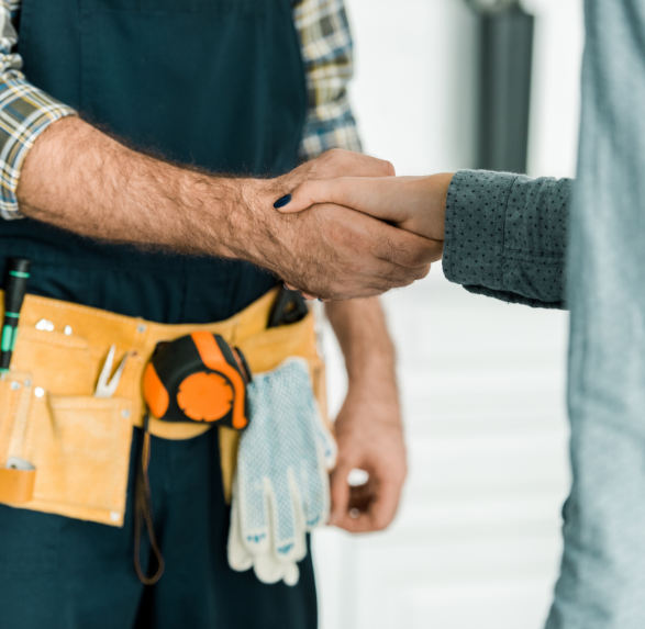 A man in an apron is shaking hands with a woman.