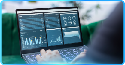Monitor displaying stock market graphs and charts on a desk with a keyboard, mouse, and notepad.
