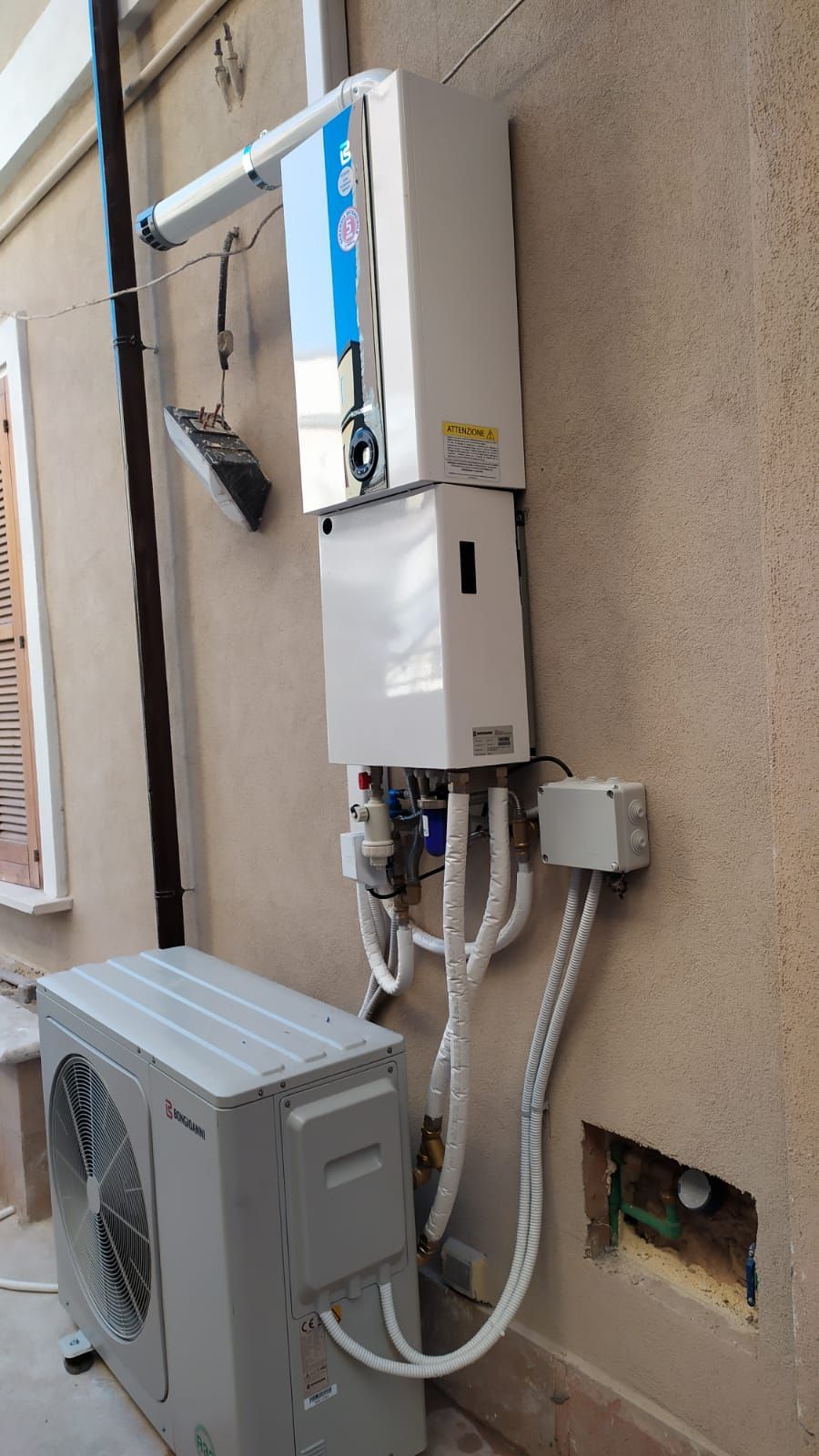 Un condizionatore bianco è posizionato sul lato di un edificio.