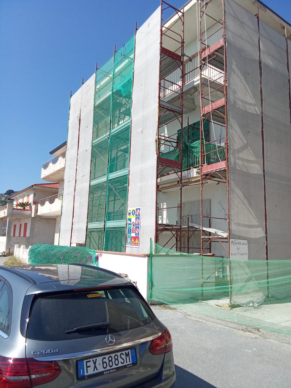 Un'auto è parcheggiata davanti a un edificio in costruzione