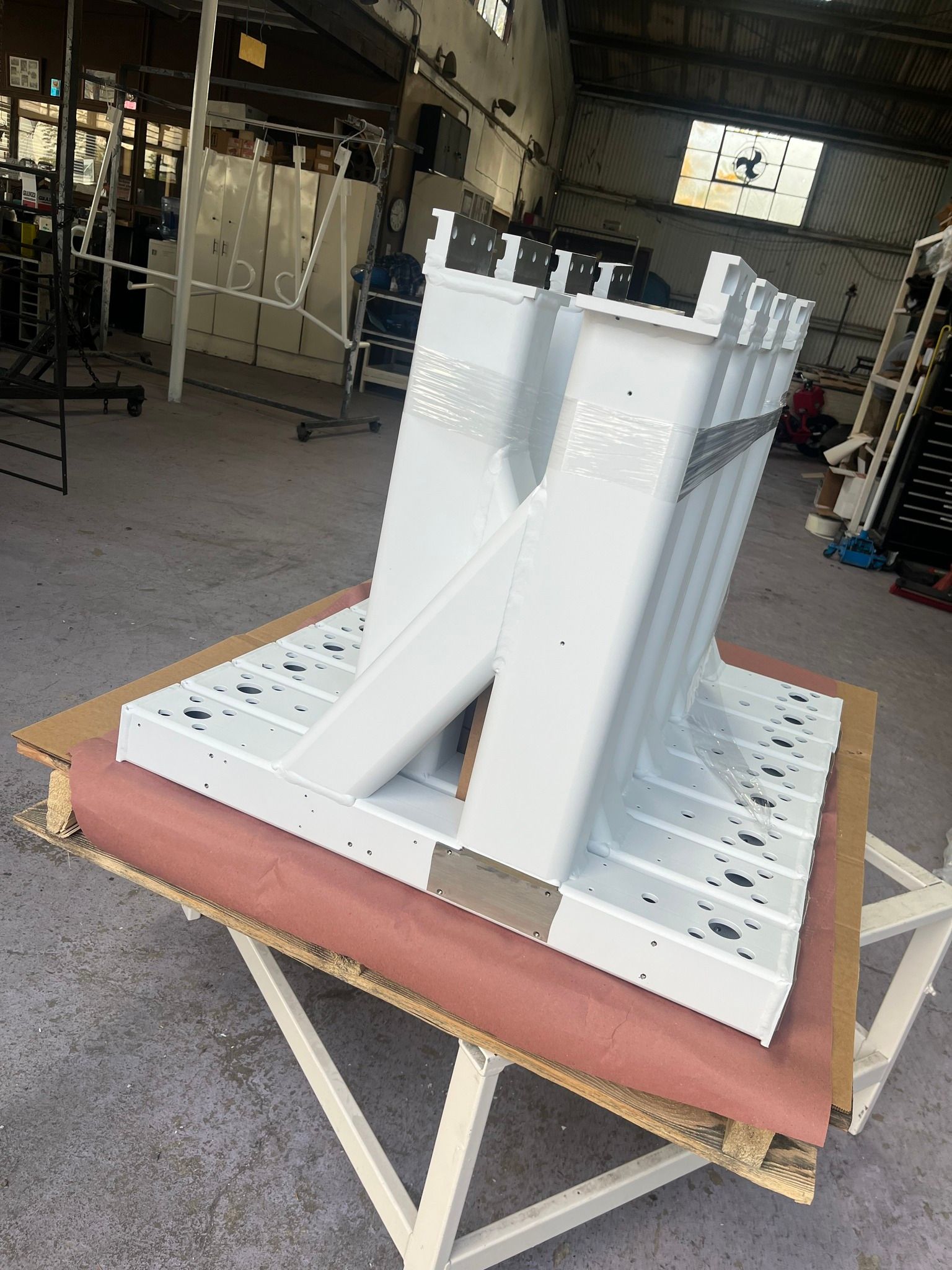 A stack of white metal pieces sitting on top of a wooden table.