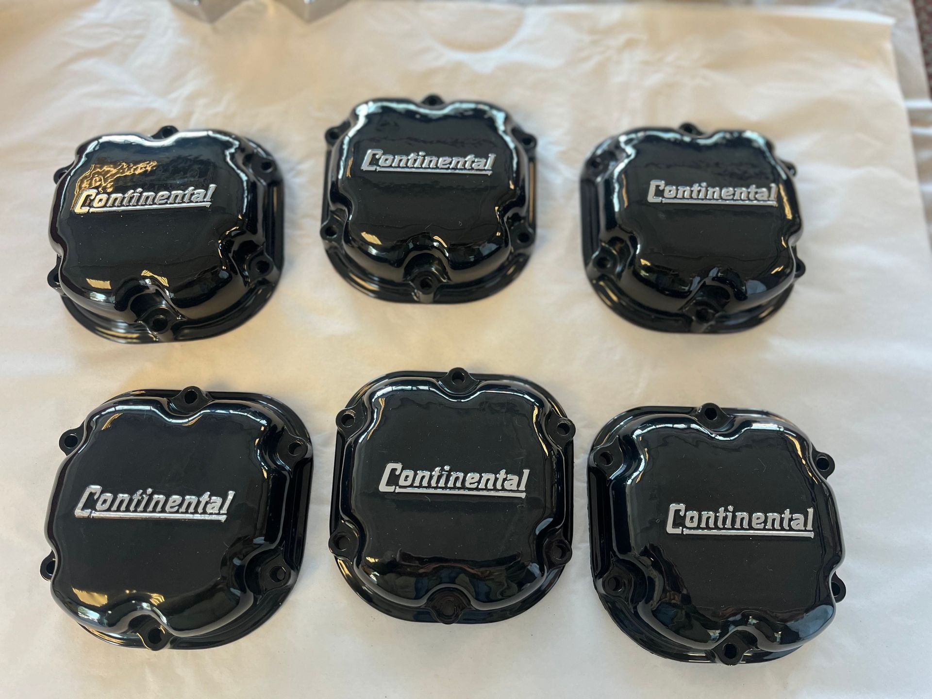 Six black continental covers are sitting on a white cloth