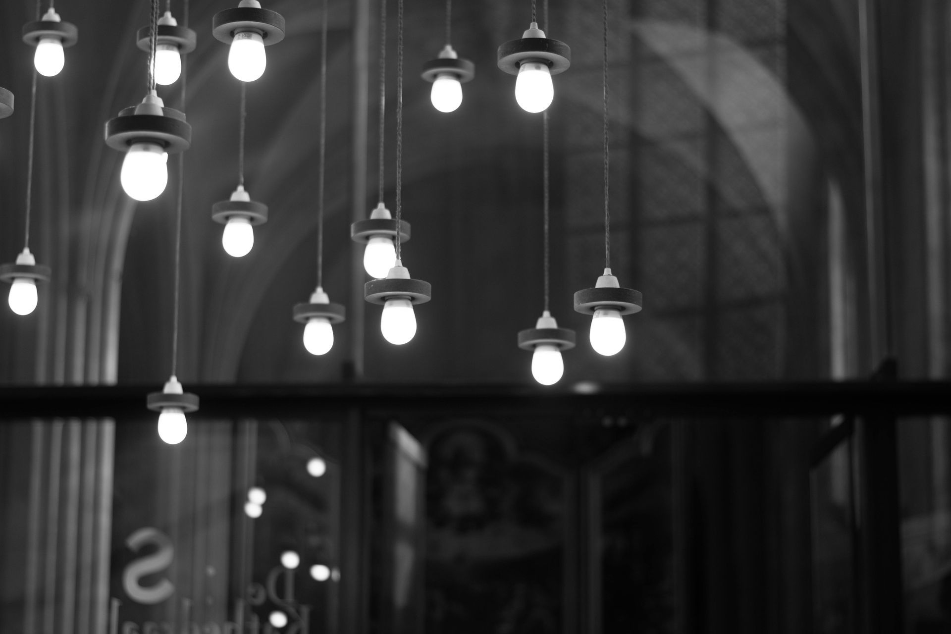 A black and white photo of a bunch of lights hanging from the ceiling
