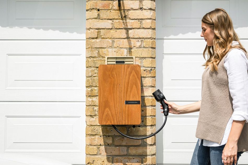 A woman is plugging an electric car into a charging station.