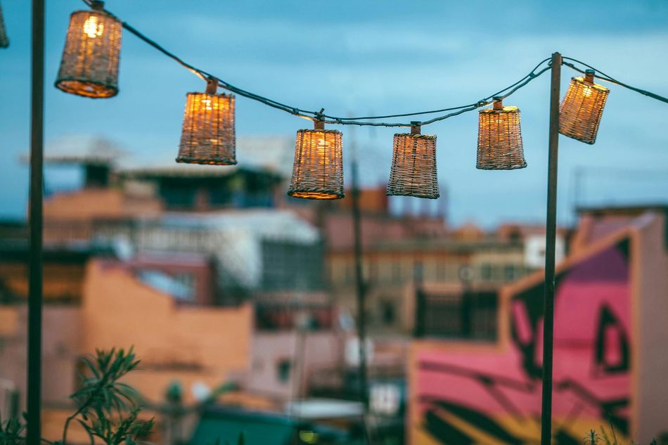A string of lights hanging from a pole in front of a city.
