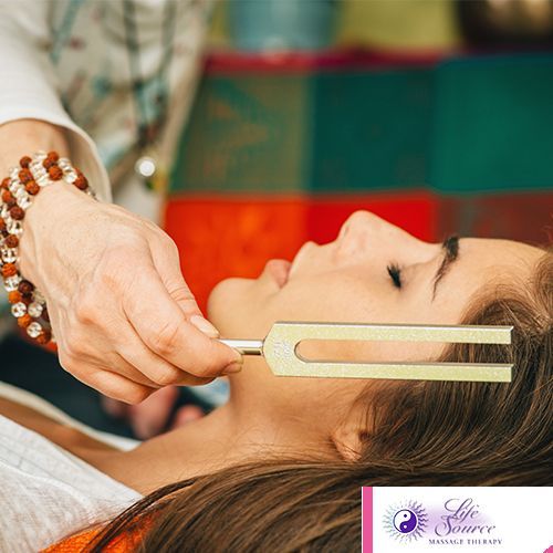 A woman is getting a massage with a fork in her neck.