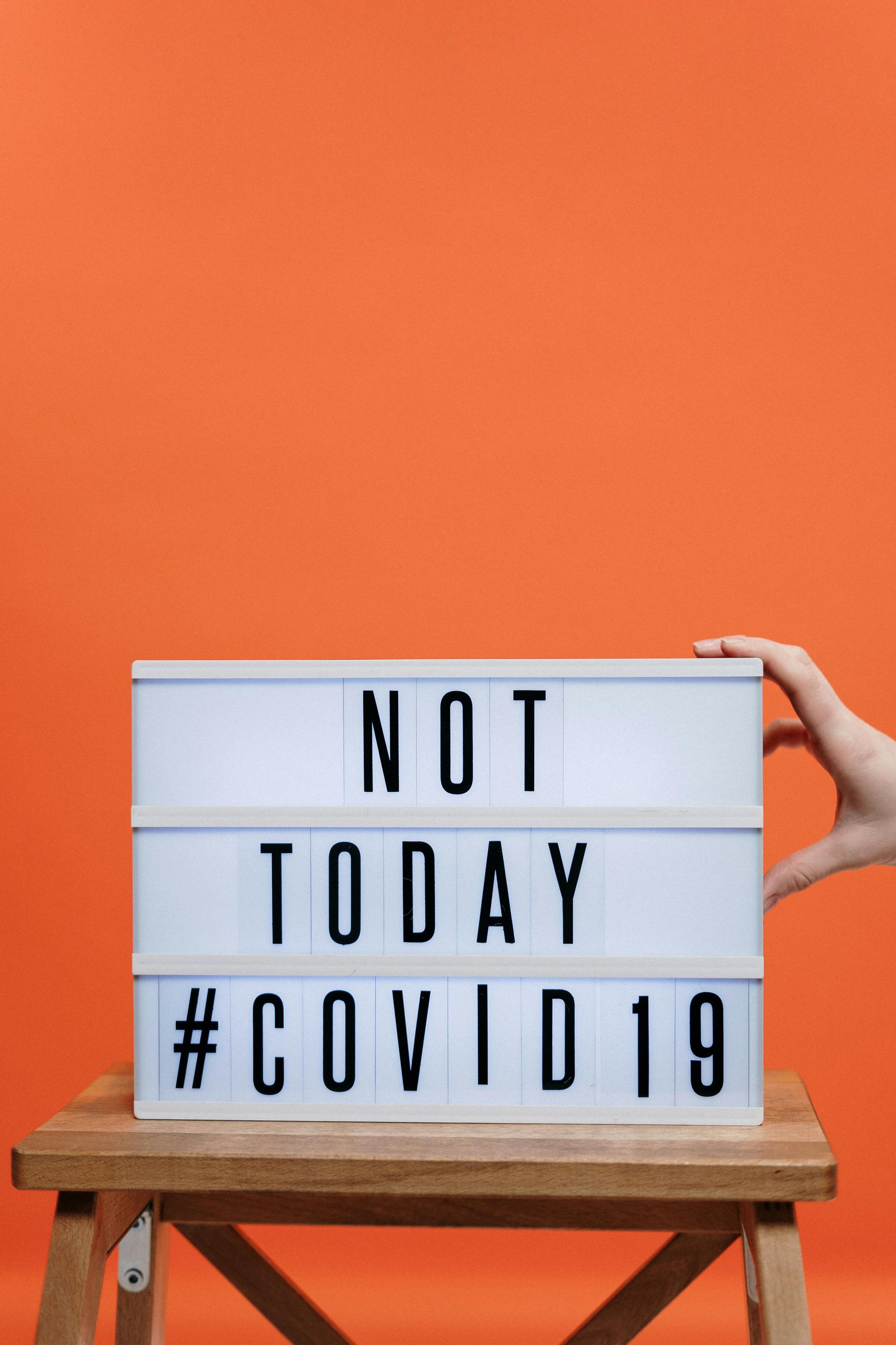 A person is holding a sign that says `` not today # covid 19 ''.