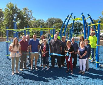 A group of people standing in front of a playground