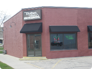 A red brick building with black awnings and a sign that says mother