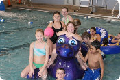 A group of children are posing for a picture in a swimming pool.