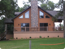 A large wooden house with a stone chimney