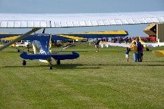 A group of people standing next to a small plane on a runway.