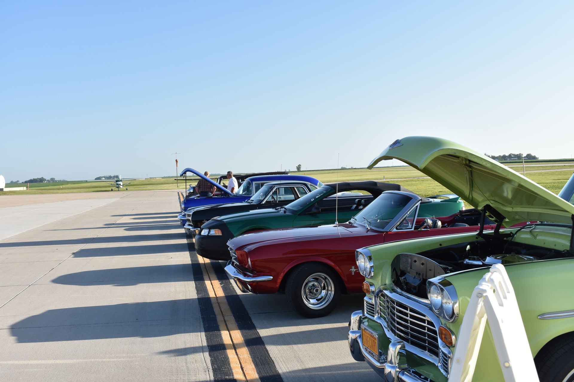 A group of cars are parked in a grassy field.