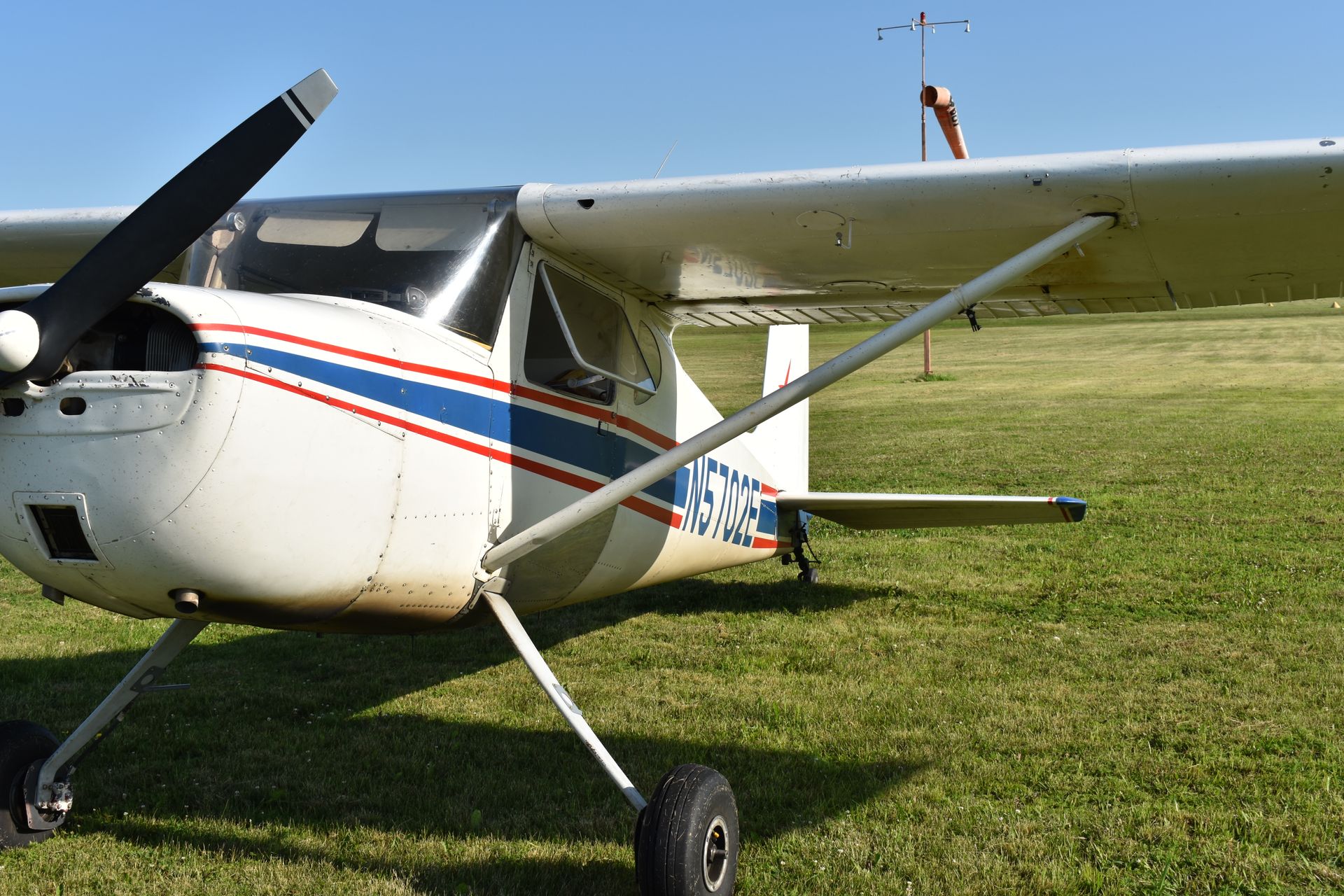 A red propeller plane is parked next to a brown propeller plane.
