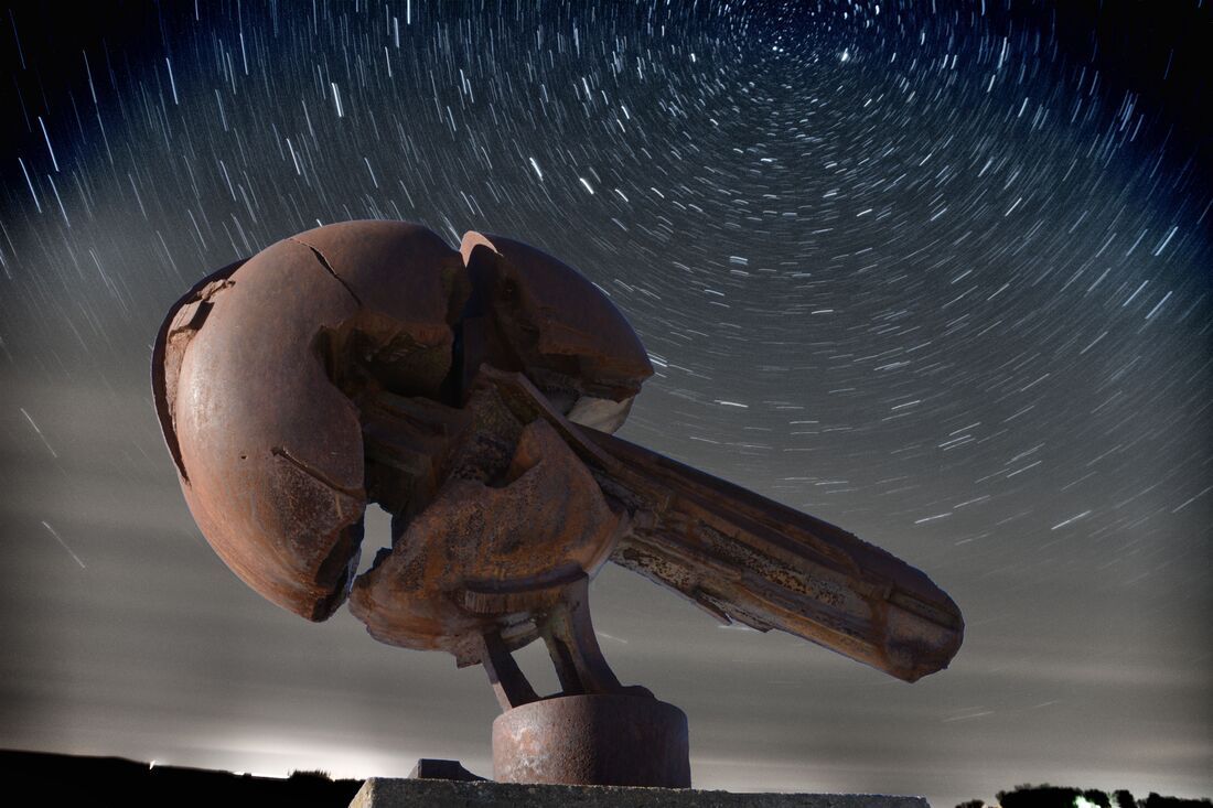 A statue with a starry sky in the background