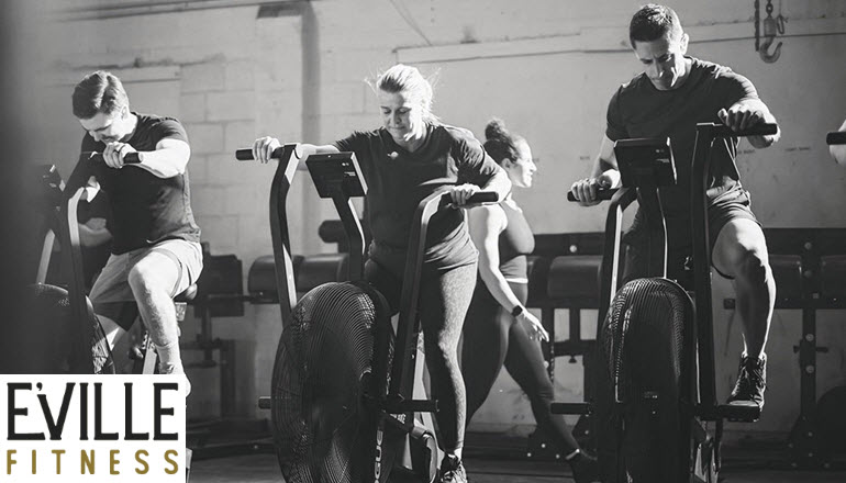 A group of people are riding exercise bikes in a gym.