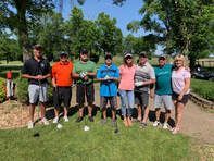 A group of people are posing for a picture on a golf course.