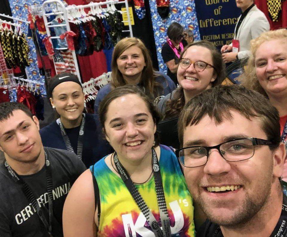 A group of people are posing for a picture in front of a sign that says world of difference