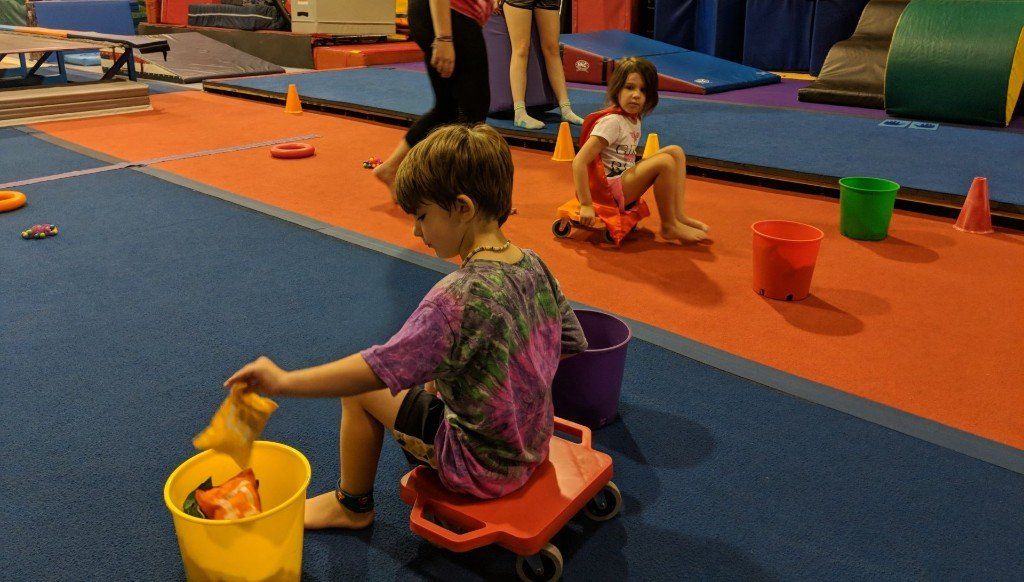 A group of children are playing with toys in a gym.