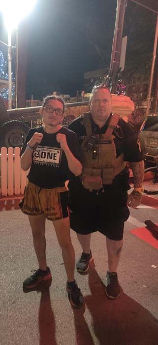 A man and a woman are standing next to each other on a street at night.