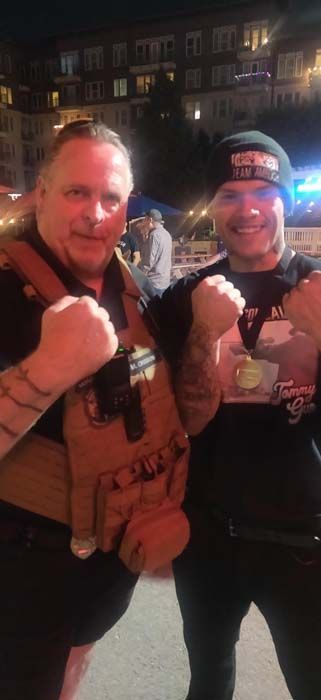 Two men are posing for a picture with their fists in the air.