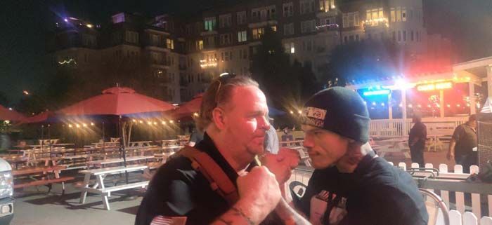 Two men are standing next to each other in a park at night.