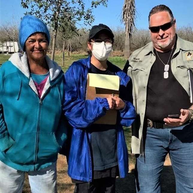 Three people wearing face masks are posing for a picture