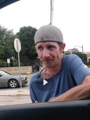 A man wearing a hat is sitting in the driver 's seat of a car.