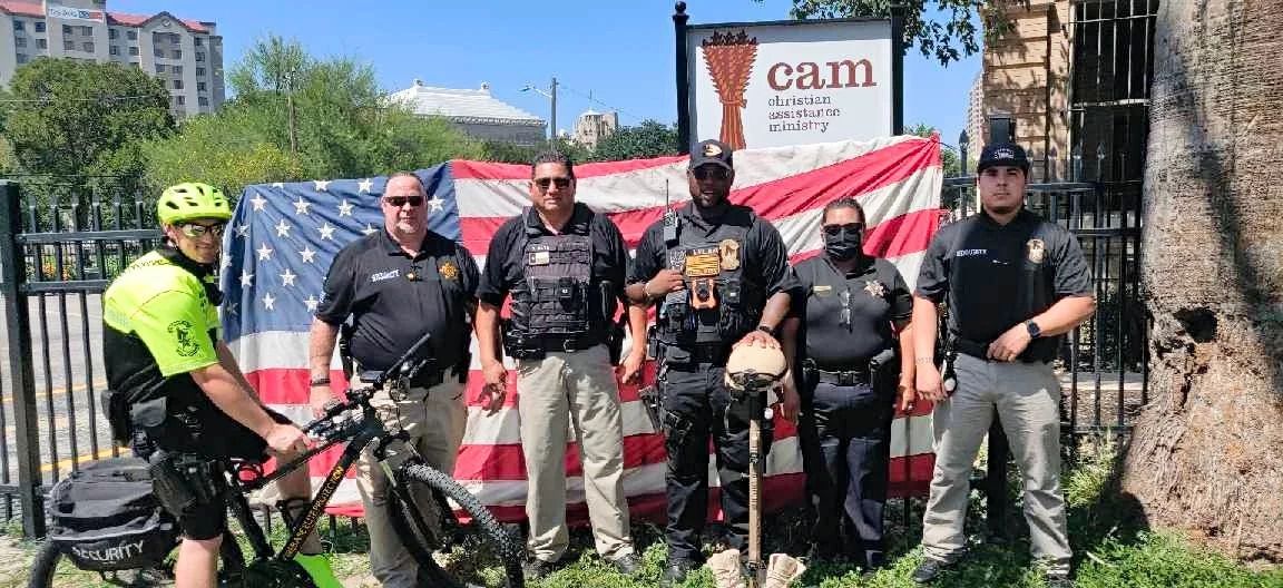 A group of police officers are standing in front of an american flag.