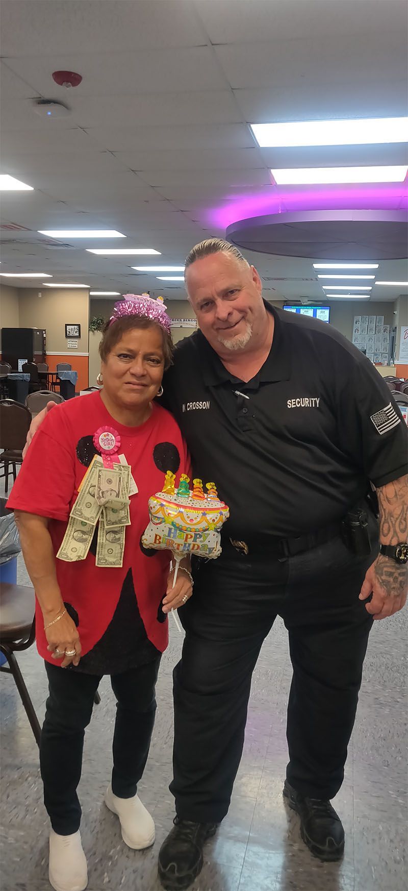 A man and a woman are standing next to each other holding a birthday cake.