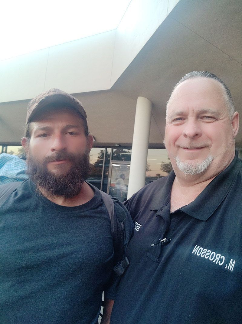 Two men with beards are posing for a picture together.