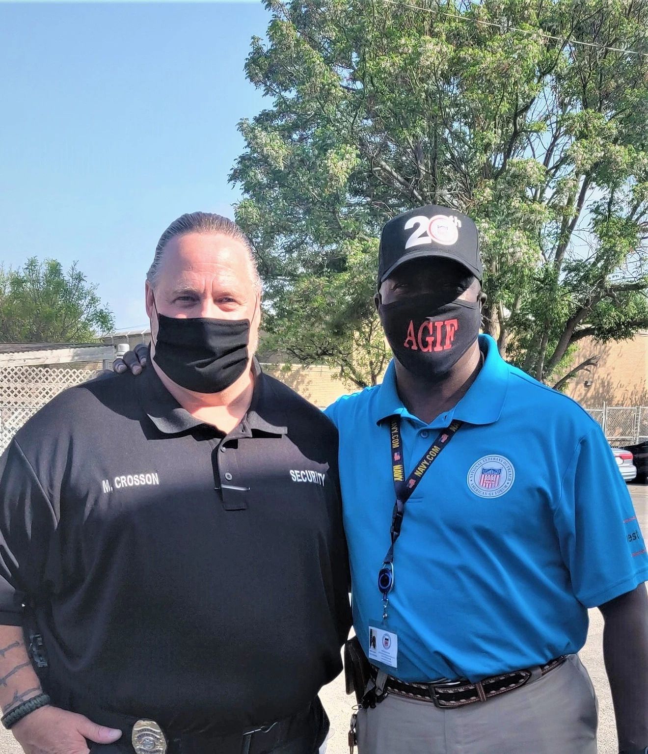 Two men wearing face masks are posing for a picture