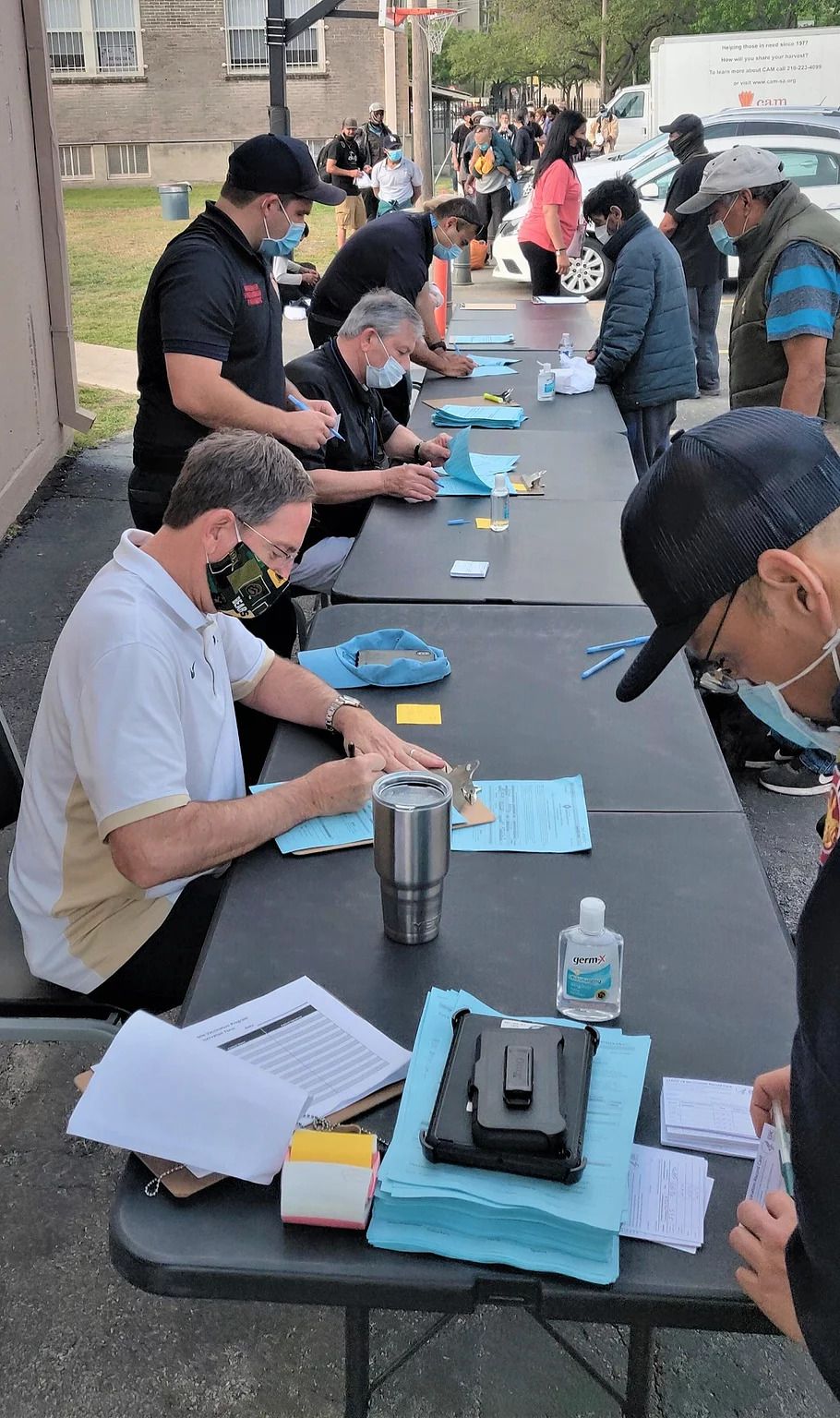 A group of men are sitting at a table signing papers.