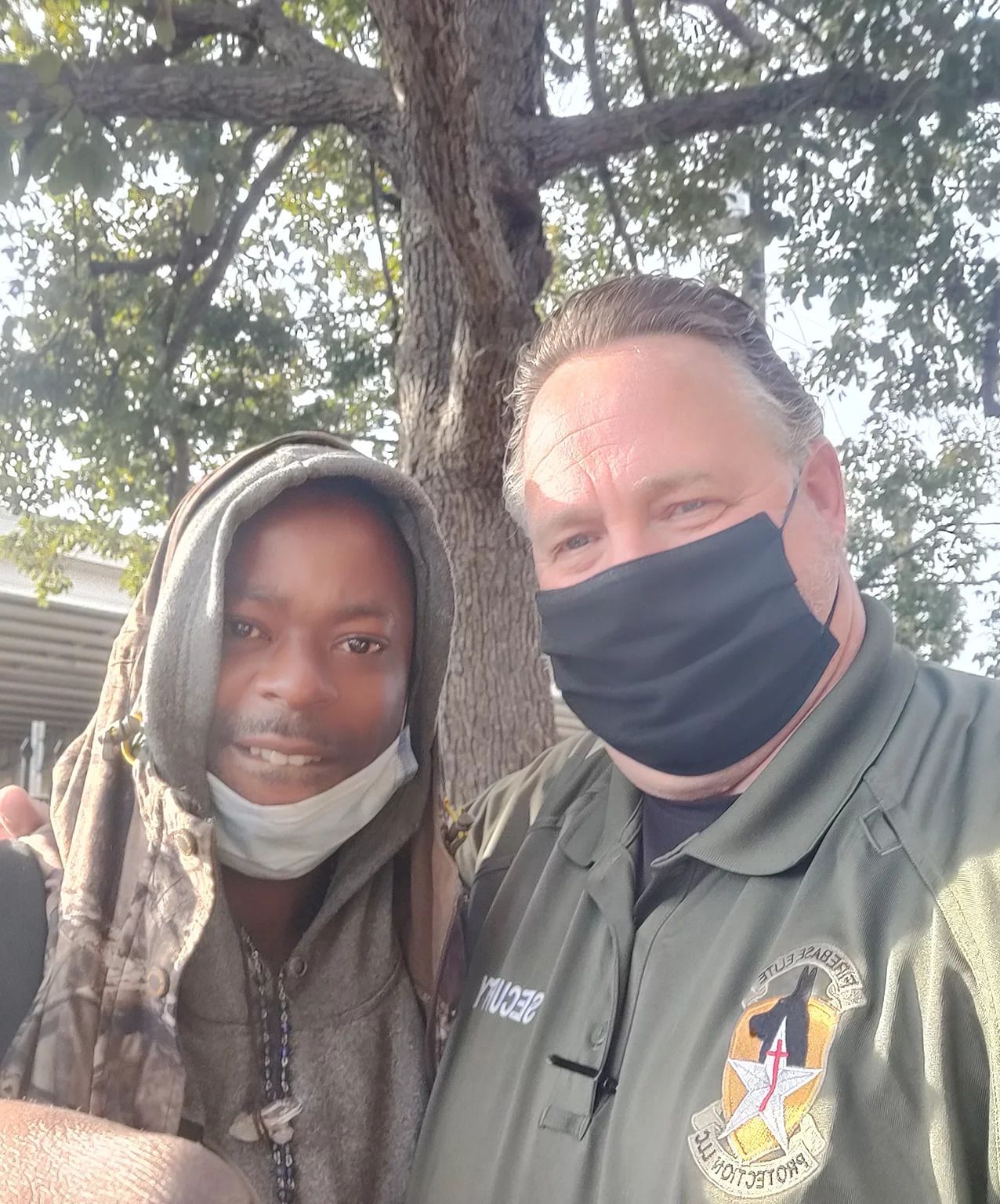 A man wearing a mask is standing next to a boy wearing a mask.