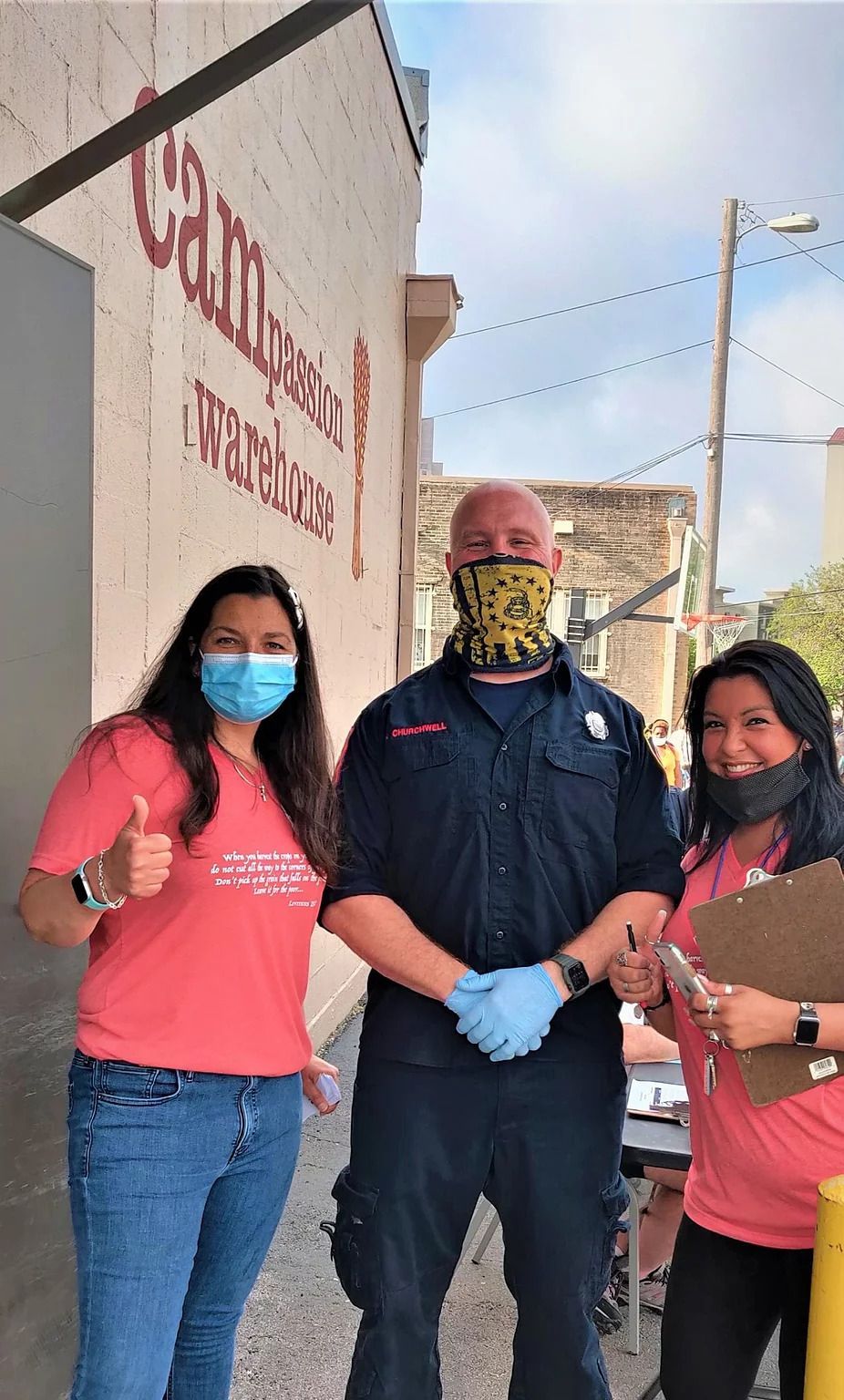 A group of people wearing face masks and gloves are standing next to each other.