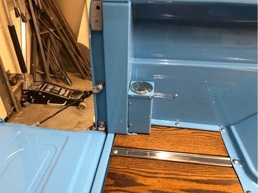 A blue truck with a wooden floor and a jack.