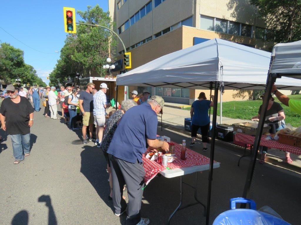 A man is standing in front of a table with a red and white checkered table cloth.