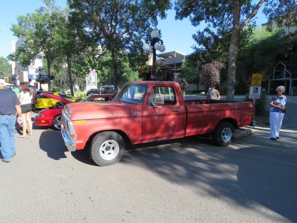 A red truck is parked on the side of the road