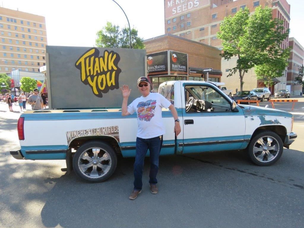 A man standing next to a truck that says thank you