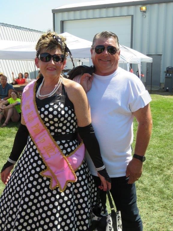 A woman in a polka dot dress is posing with a man in a white shirt