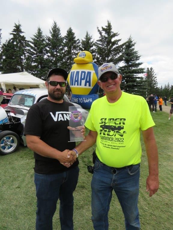 Two men shaking hands in front of a napa balloon