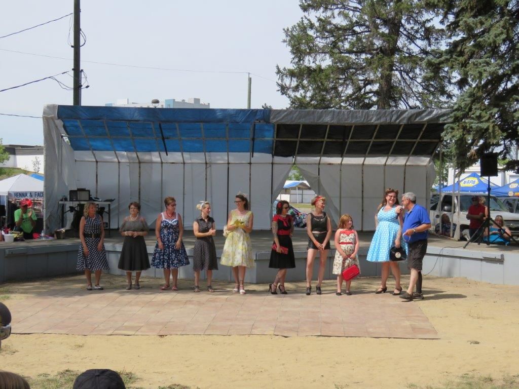 A group of women are standing in front of a stage.