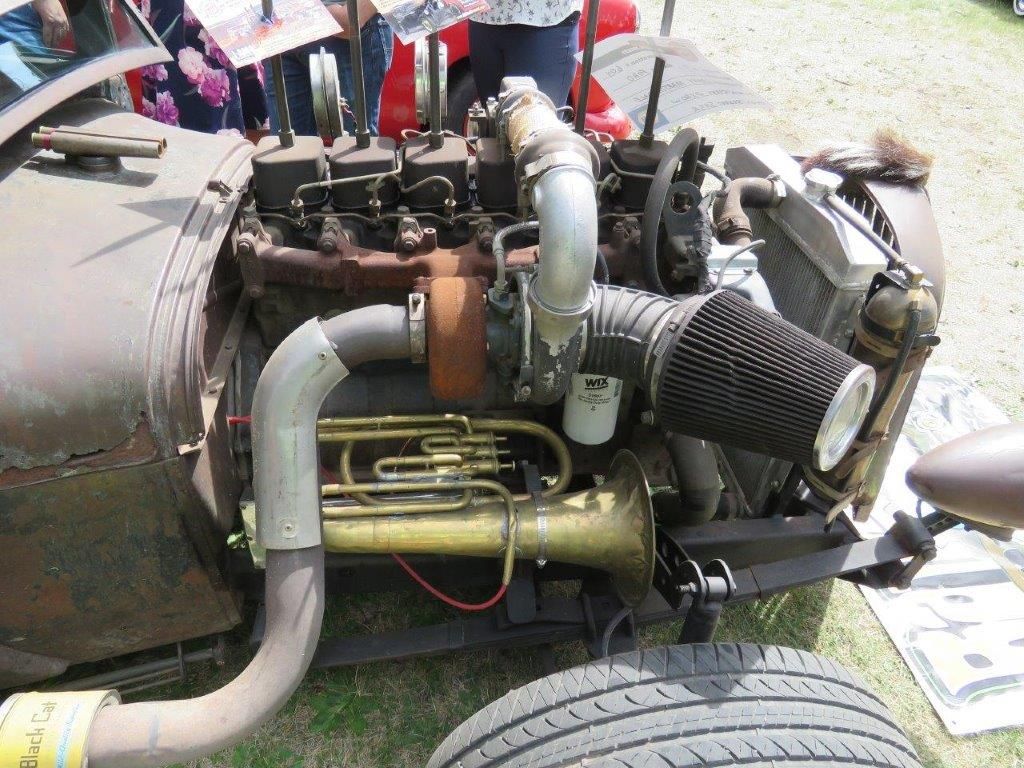 A close up of a car engine with a trumpet attached to it