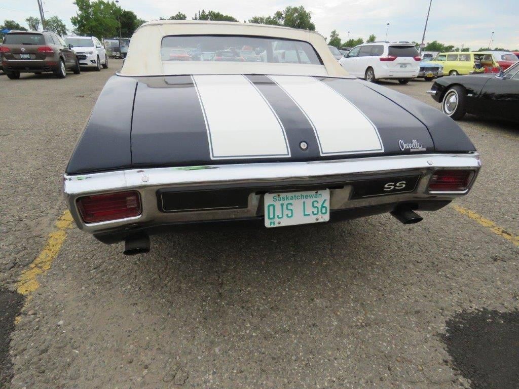 A black and white car with a license plate that says ojs l56