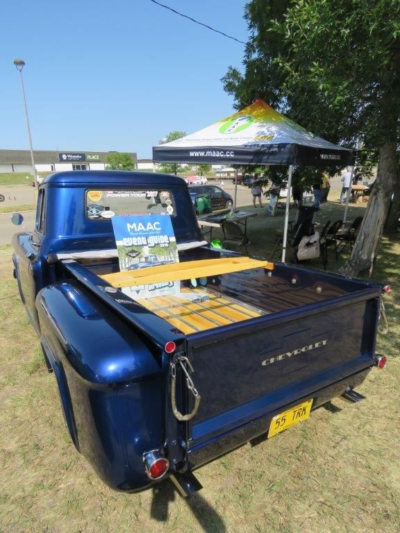 A blue truck with a wooden shelf in the back