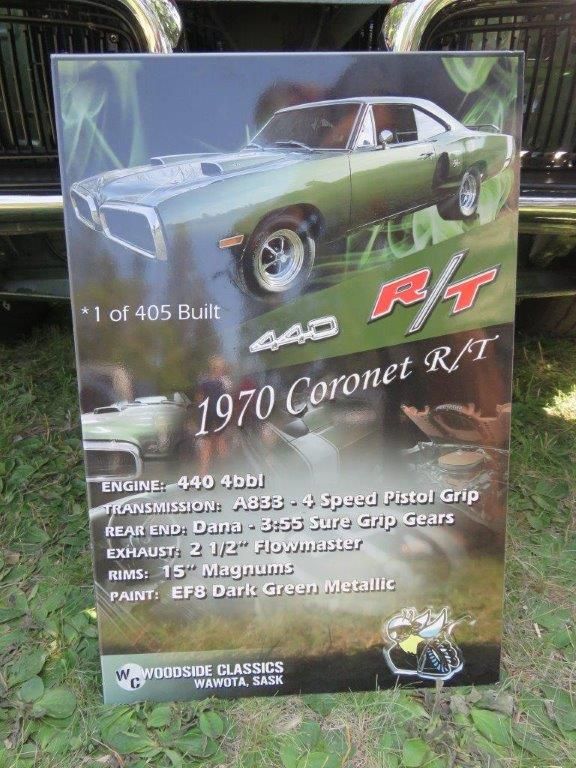 A poster of a 1970 coronet r / t is sitting in front of a car.