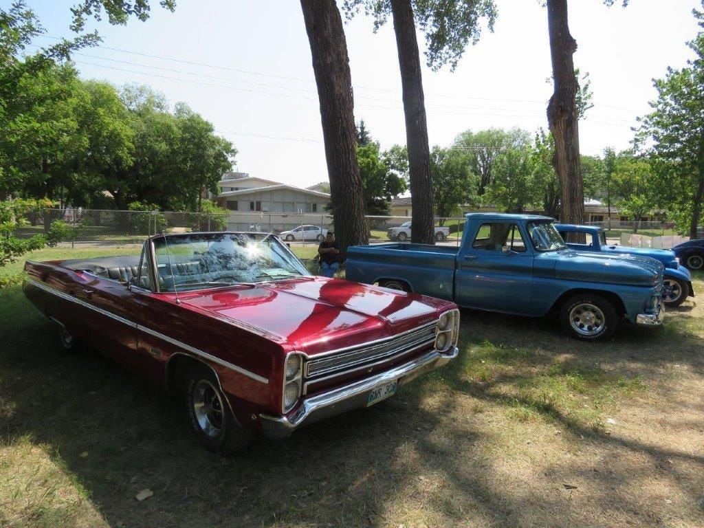 A red car and a blue truck are parked next to each other.